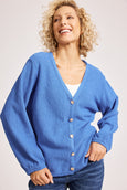 Woman wearing a blue eb & ive cardigan with a plain background