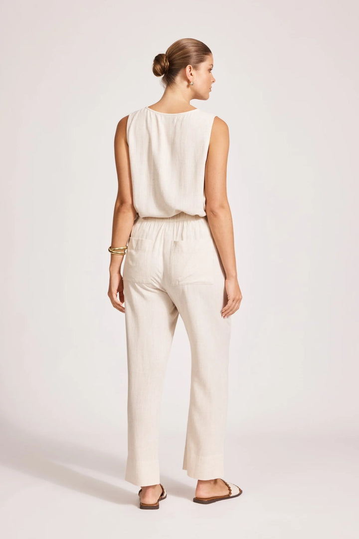 Woman wearing a white eb & ive sleeveless top and pants on a light pink background
