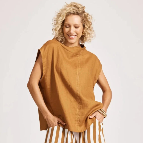 Woman wearing a eb & ive mustard yellow sleeveless top with a white background