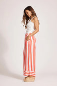 Woman wearing a white top and eb & ive red and white striped pants on a light background