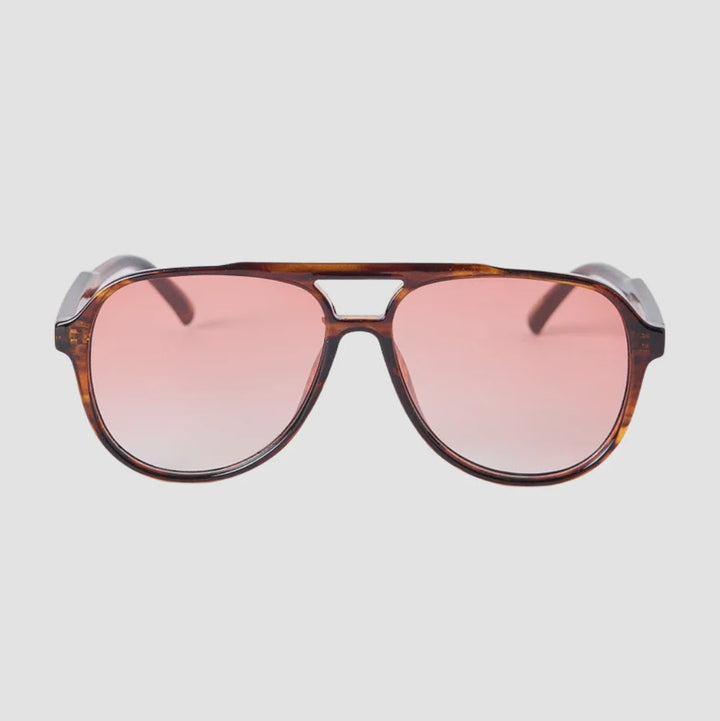 A pair of aviator-style sunglasses with a brown tortoiseshell frame and pink gradient lenses, shown from the front on a light gray background.