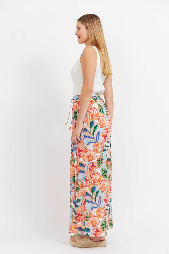 Woman wearing a colorful haven floral pants on a white background