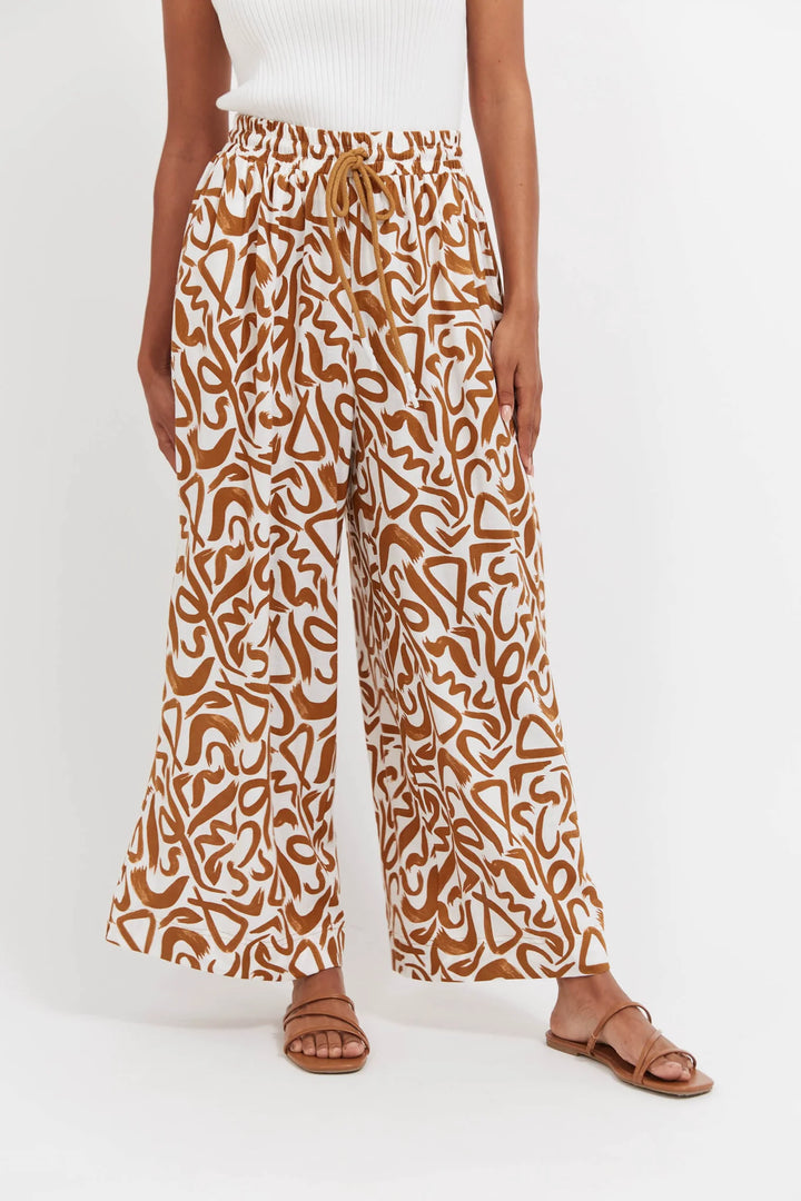 Person wearing haven brown patterned pants on a white background