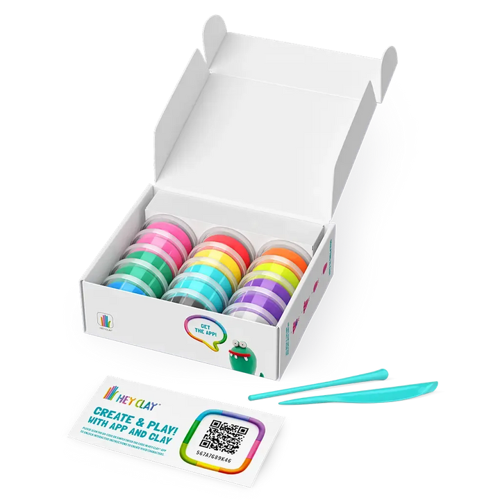 Box of colorful clay pots with tools on a white background