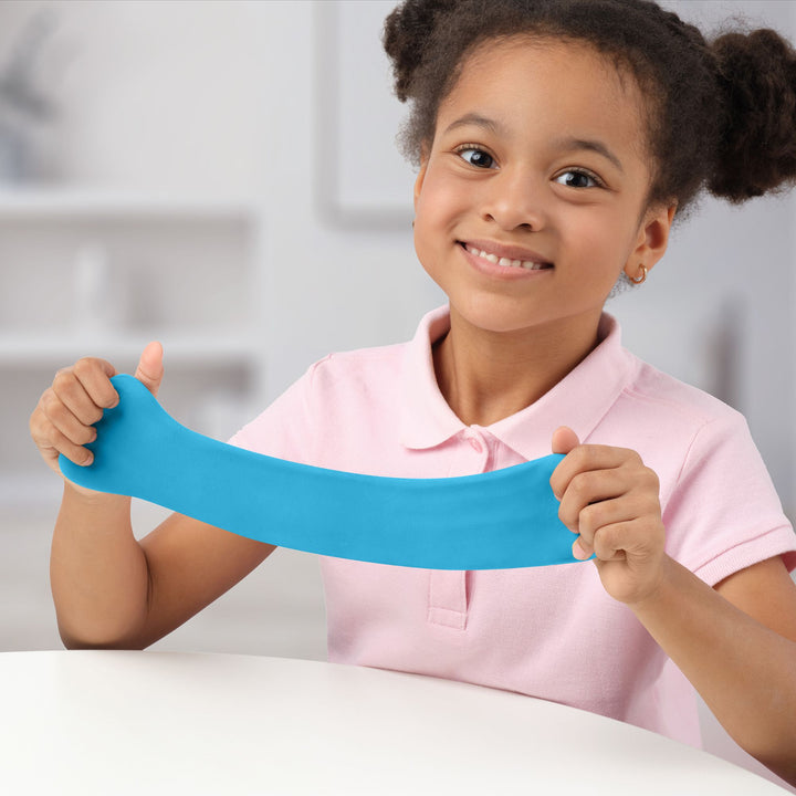 Young girl holding a blue object against a blurred indoor background