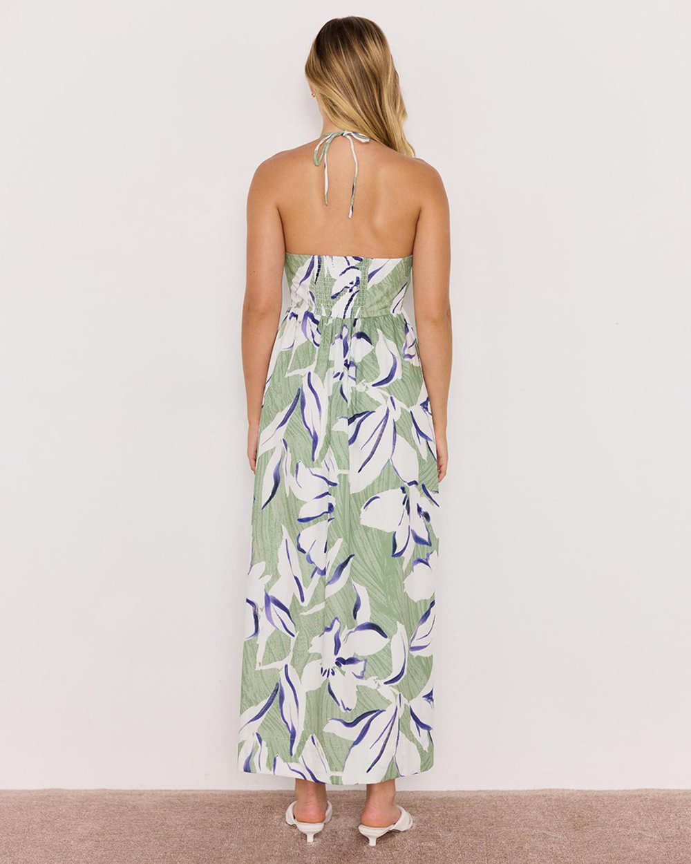 Woman wearing a strapless floral dress with a white background