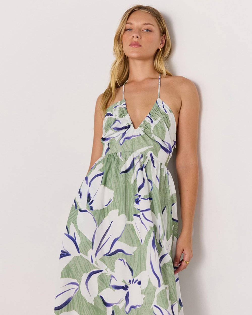 Woman wearing a green floral dress against a white background