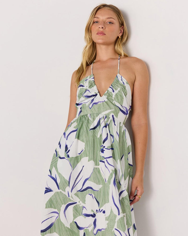 Woman wearing a green floral dress against a white background