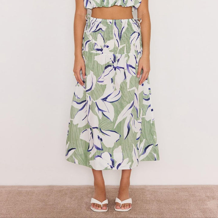Woman wearing a green floral dress against a white background