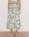 Person wearing a green floral skirt with a white background