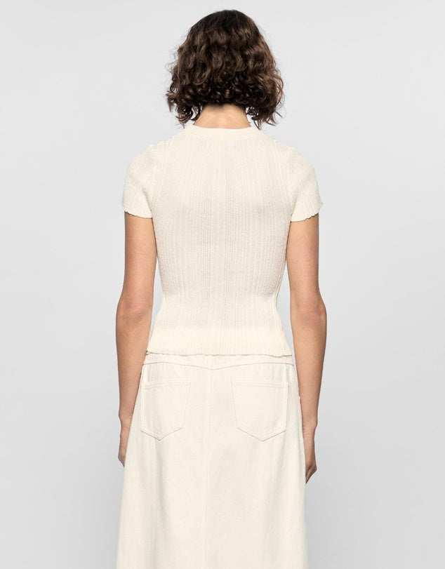 Person wearing a white dress against a plain background