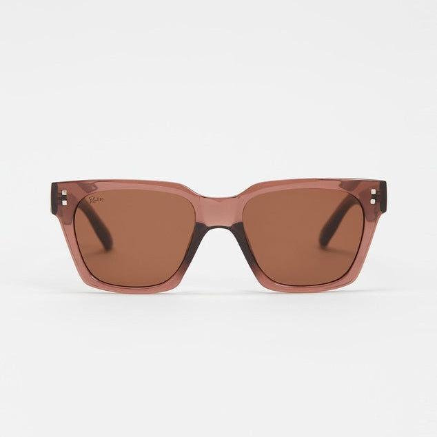 A pair of square sunglasses with a translucent dusty rose pink frame and brown lenses, shown against a plain light gray background.