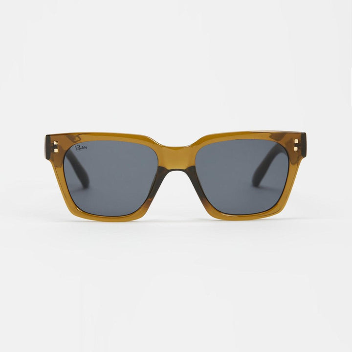 A pair of square sunglasses with a translucent amber-brown acetate frame and dark gray lenses, shown against a plain light gray background.