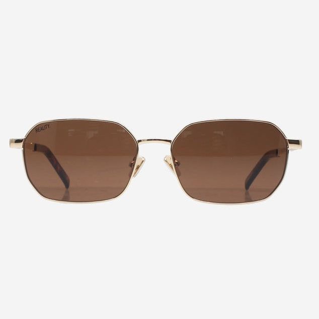 Oversized square sunglasses with a gold metal frame and brown tinted lenses, shown against a plain light gray background.