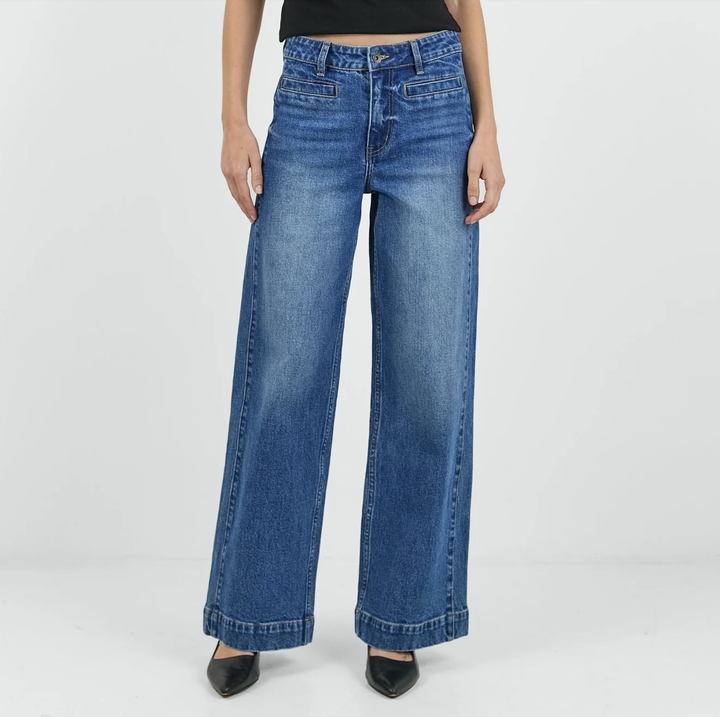 Person wearing blue wide-leg jeans on a plain background