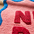 Close-up of a textured pink surface with red letters spelling 'NRA'.