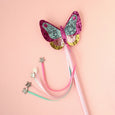 Colorful butterfly hair clip with ribbons on a pink background