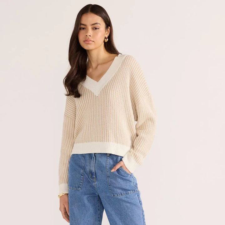 Woman wearing Minkpink beige sweater on a plain background, available from The Collective