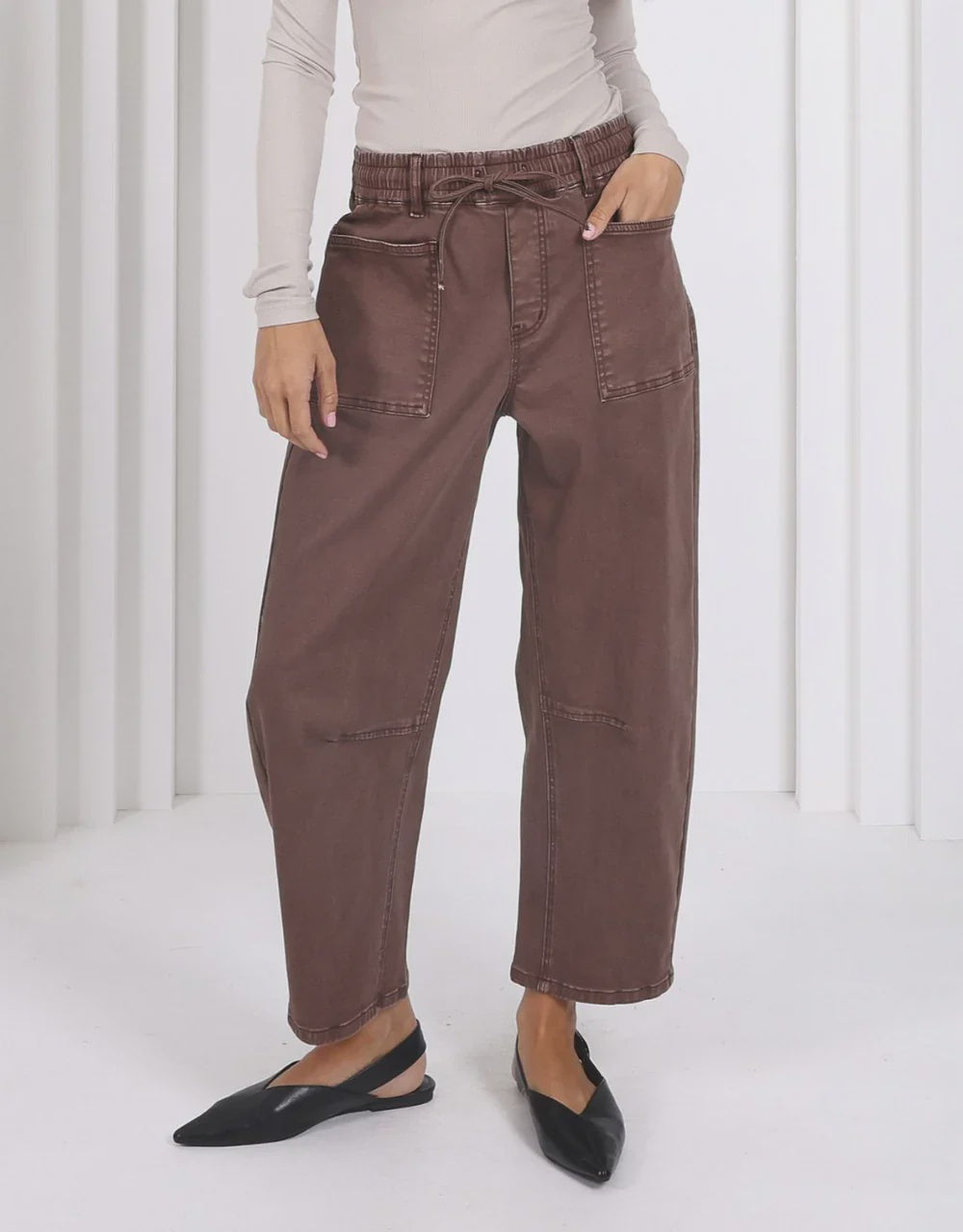 Person wearing brown pants with a white background