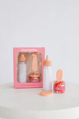 Baby product set with bottles and jar on a white surface, featuring 'tiny harlow' branding.