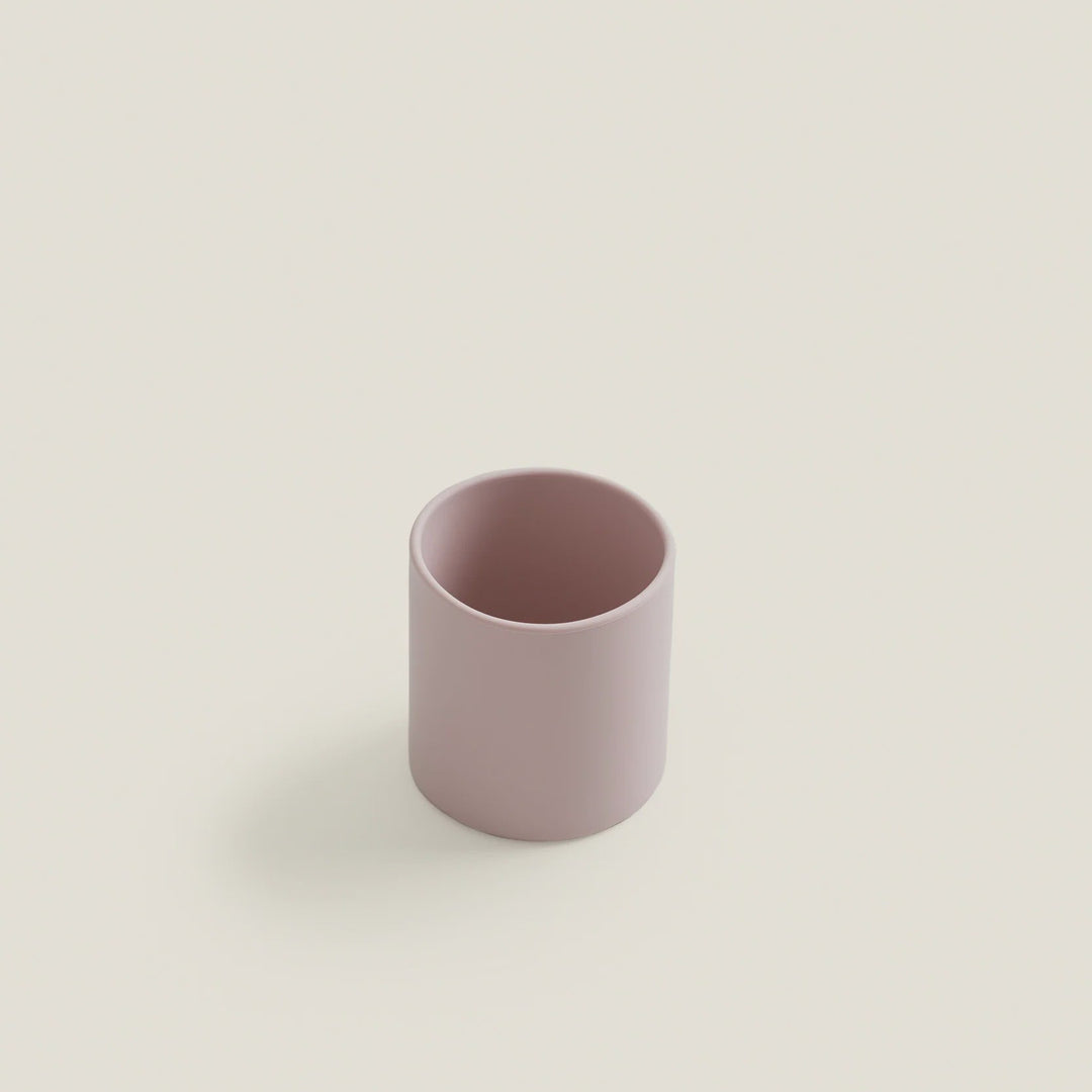 Pink ceramic cup on a light beige background