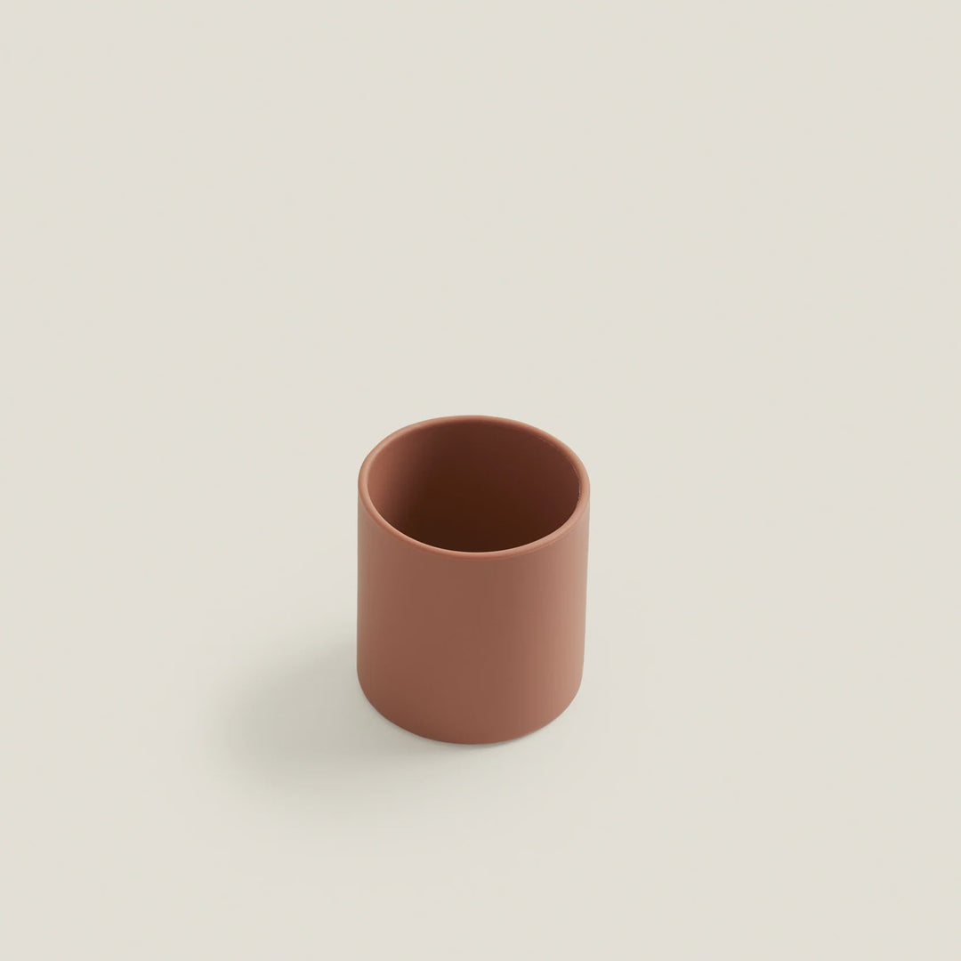 Brown ceramic cup on a light beige background