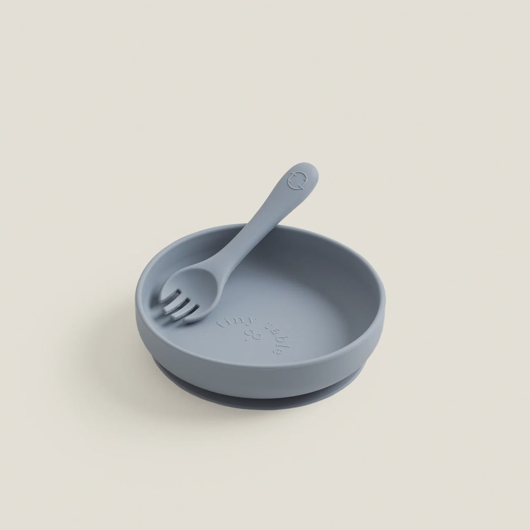 Blue silicone plate with fork on a beige background
