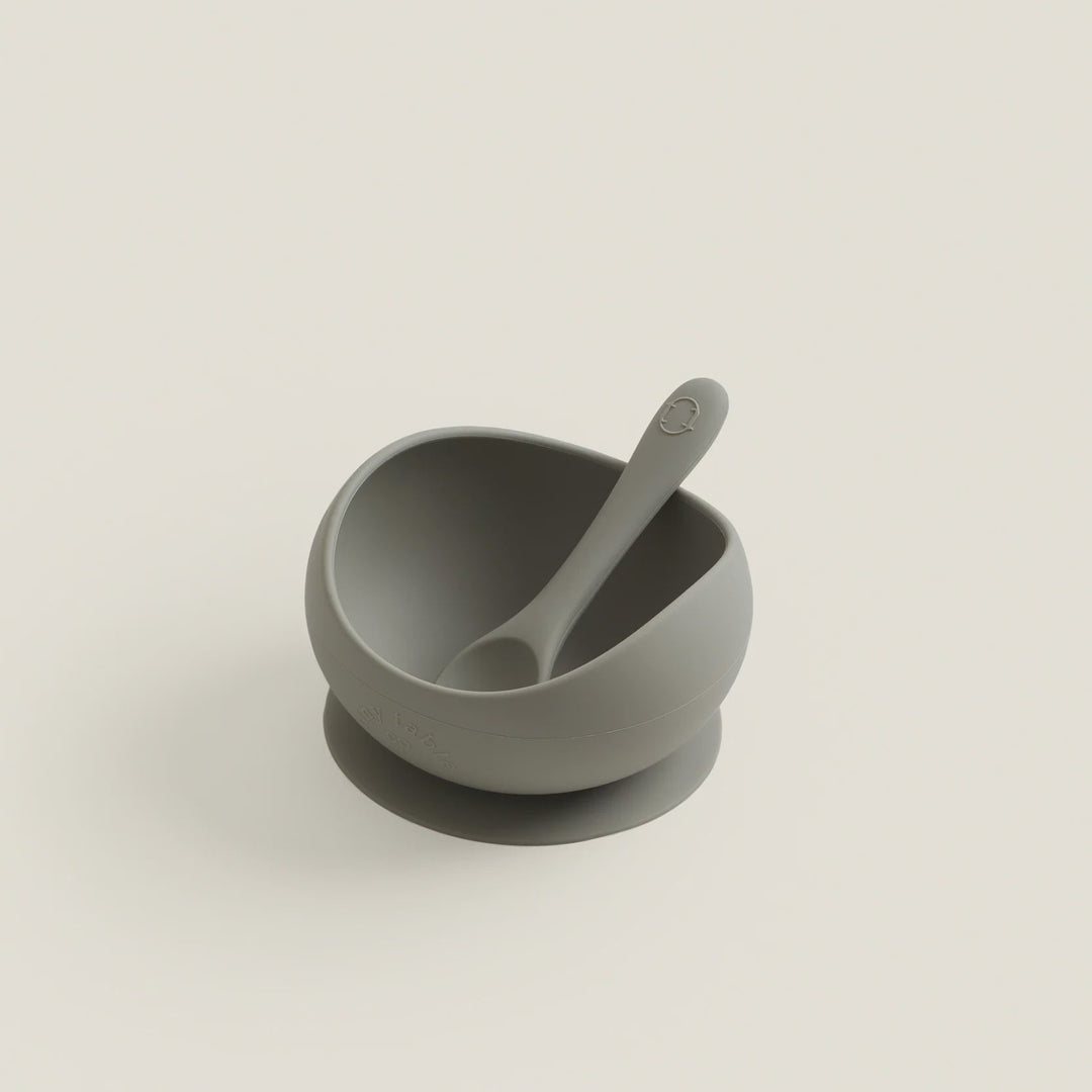 Gray mortar and pestle on a light beige background