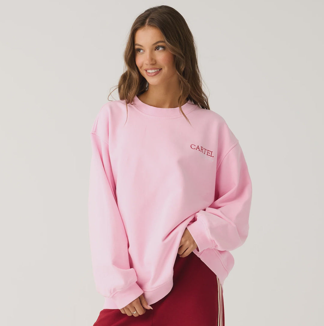 Woman wearing a pink sweatshirt and red pants on a white background