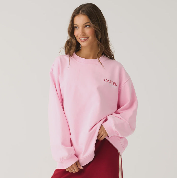 Woman wearing a pink sweatshirt and red pants on a white background