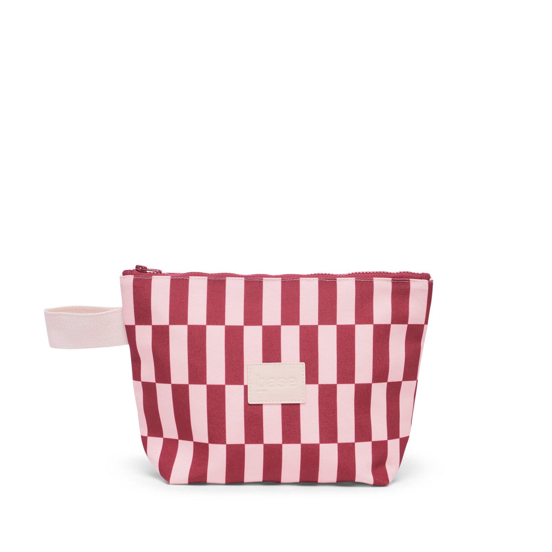 Pink and red striped bag with a white zipper on a white background