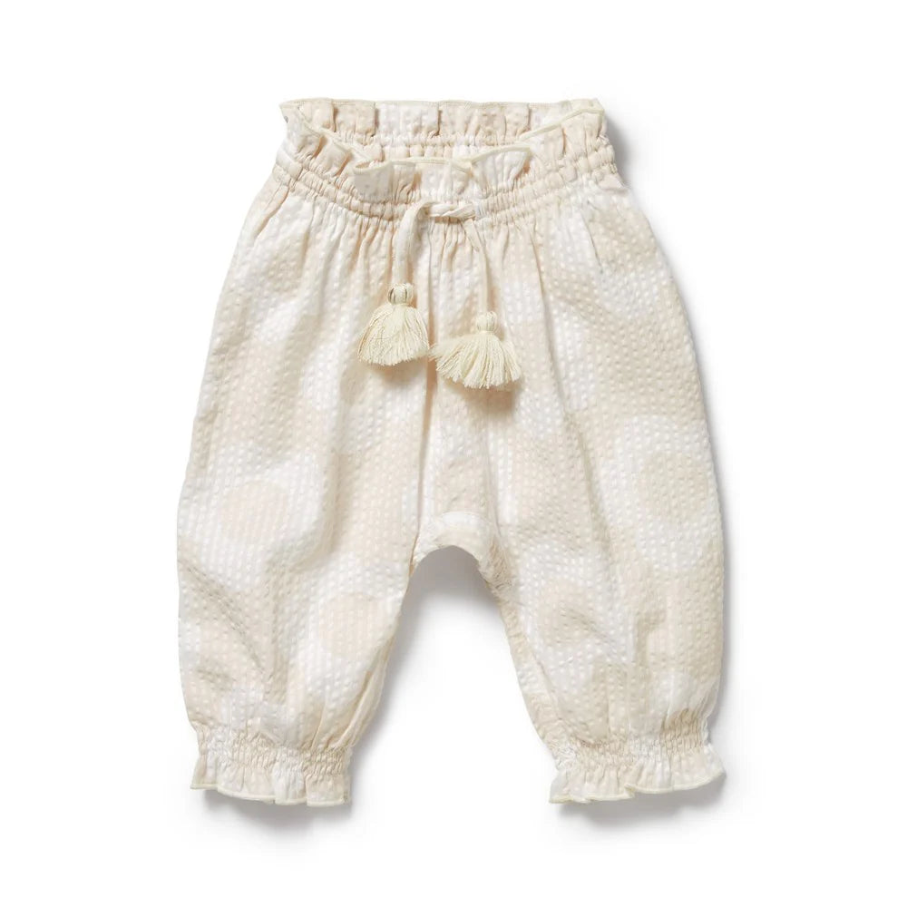 White Wilson & Frenchy baby pants with tassels on a white background