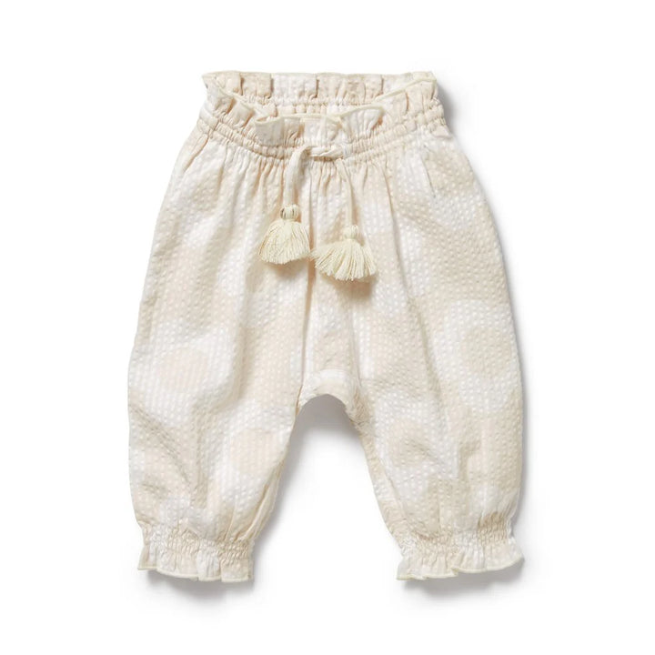White Wilson & Frenchy baby pants with tassels on a white background