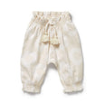 White Wilson & Frenchy baby pants with tassels on a white background