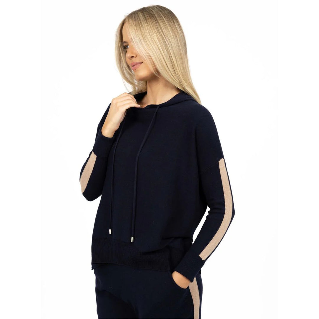 Woman wearing a navy blue hoodie with beige accents on a white background