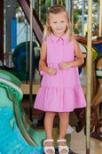 Young girl in a pink dress standing on a carousel