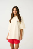 Woman wearing a beige oversized t-shirt and red shorts on a white background