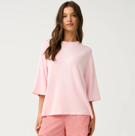 Woman wearing a pink top and checkered shorts on a white background