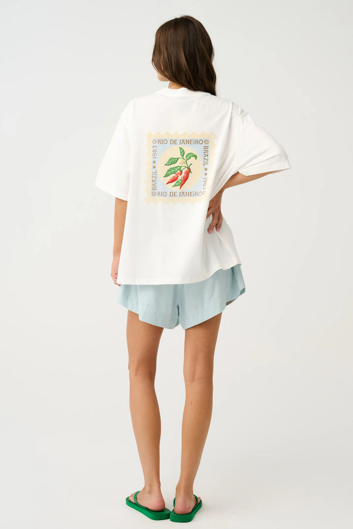 Person wearing a white t-shirt with a graphic design on the back, standing against a plain background.