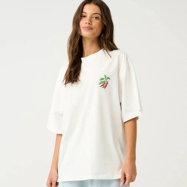 Woman wearing a white oversized shirt with a small design and light blue shorts on a white background