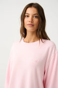 Woman wearing a light pink sweatshirt against a white background