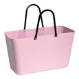 Pink plastic tote bag with black handles on a white background