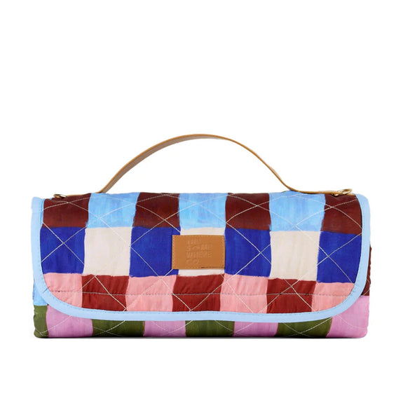 The Somewhere co Multicolored quilted picnic rug with a handle on a white background