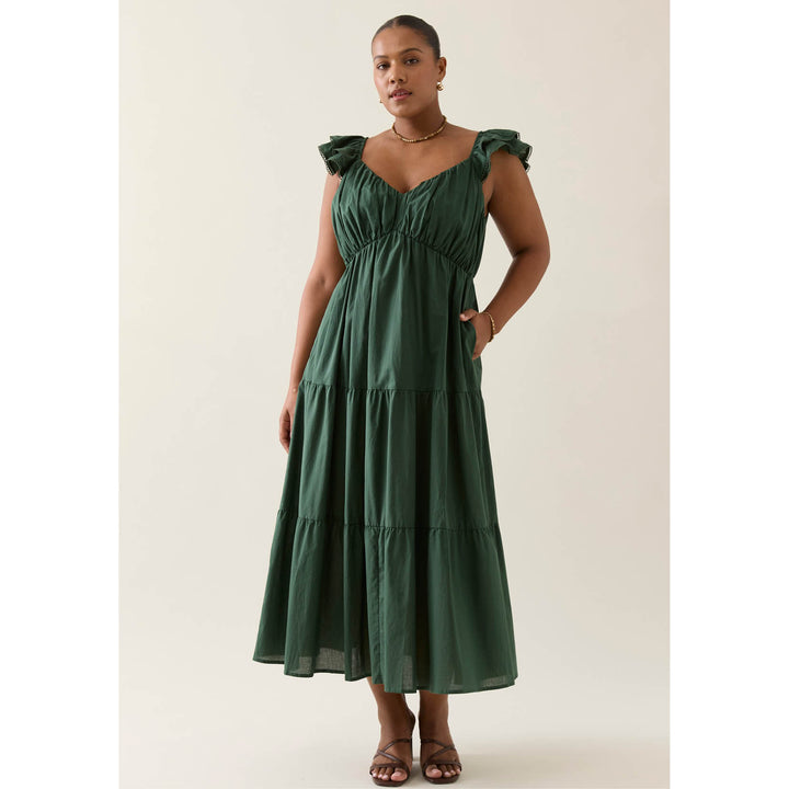 Woman wearing a green  isle of mine dress against a white background