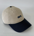 Beige and navy cap with 'LAWN GOLF' text on a light gray background