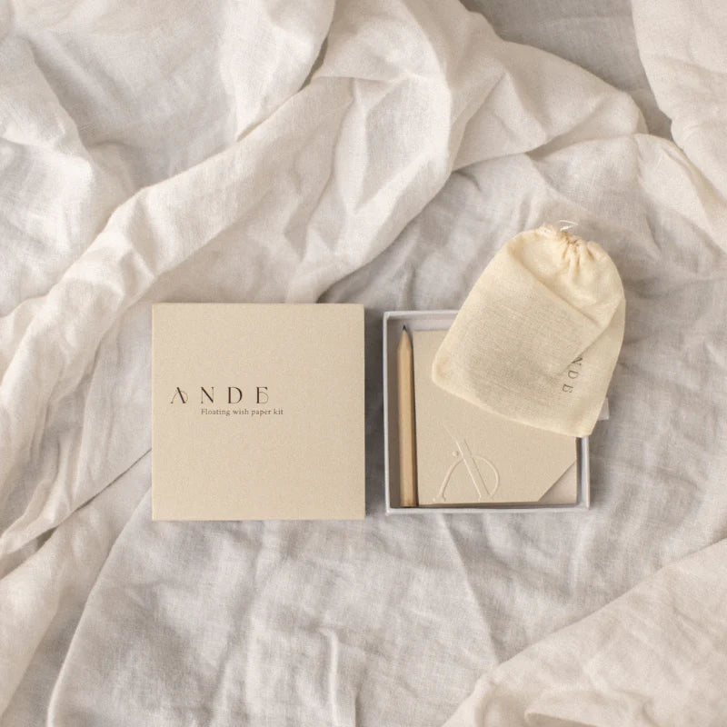 Product packaging with 'ANDE' branding on a soft fabric background