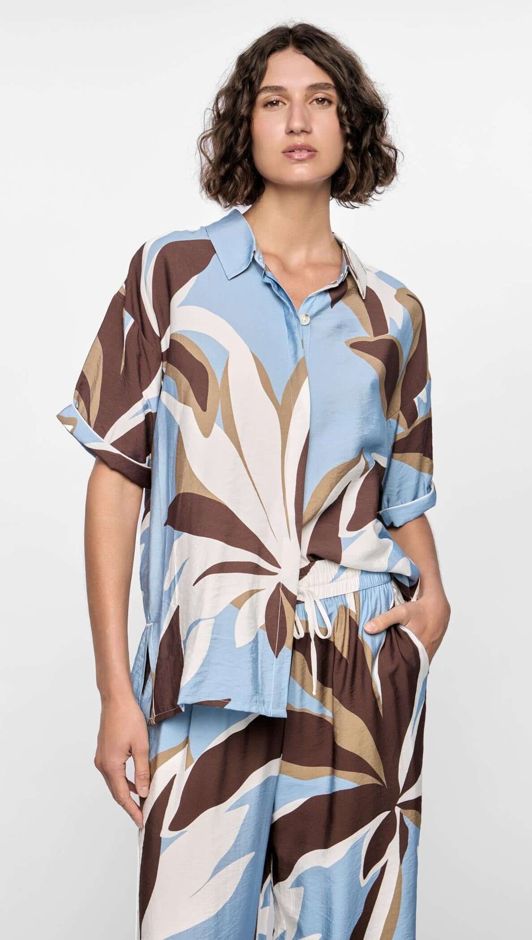 Woman wearing a patterned outfit with a white background