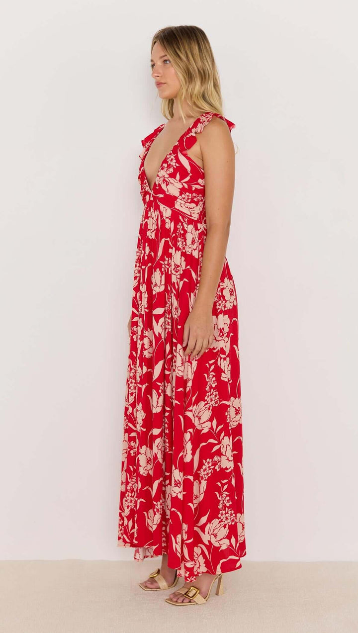 Woman wearing a red floral dress against a white background