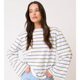 Woman wearing a cartel & willow white and green river striped long-sleeve shirt against a plain background