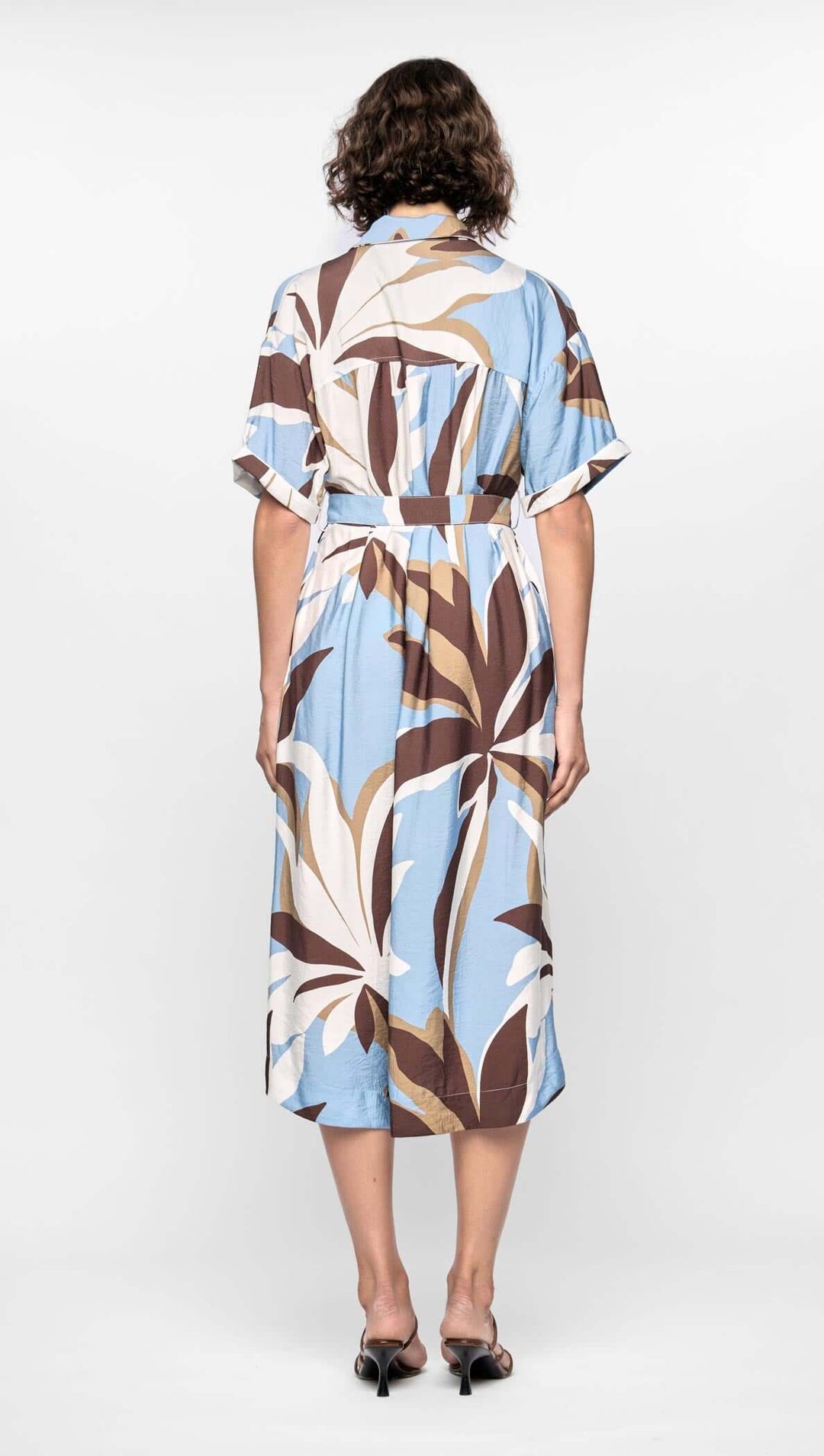 Woman wearing a patterned dress on a white background